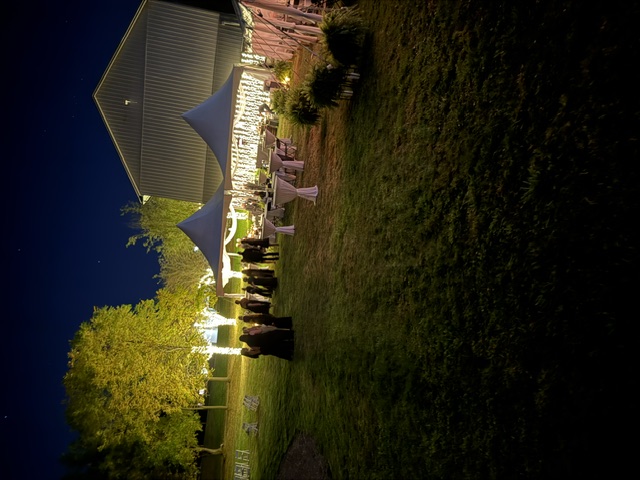 Guests gathered under lighted reception tents at an evening event