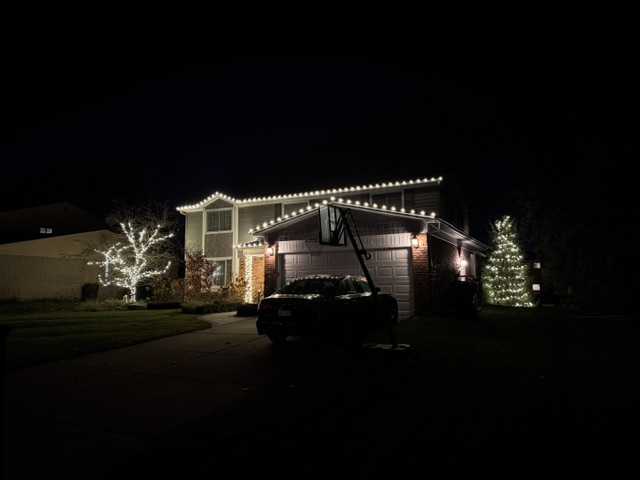 Residential home with warm-white roofline holiday lighting