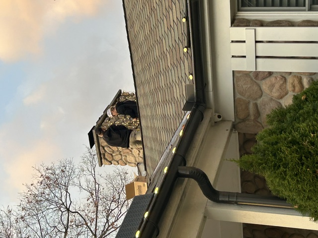LuxeGlow installers working on a chimney lighting installation from the roof